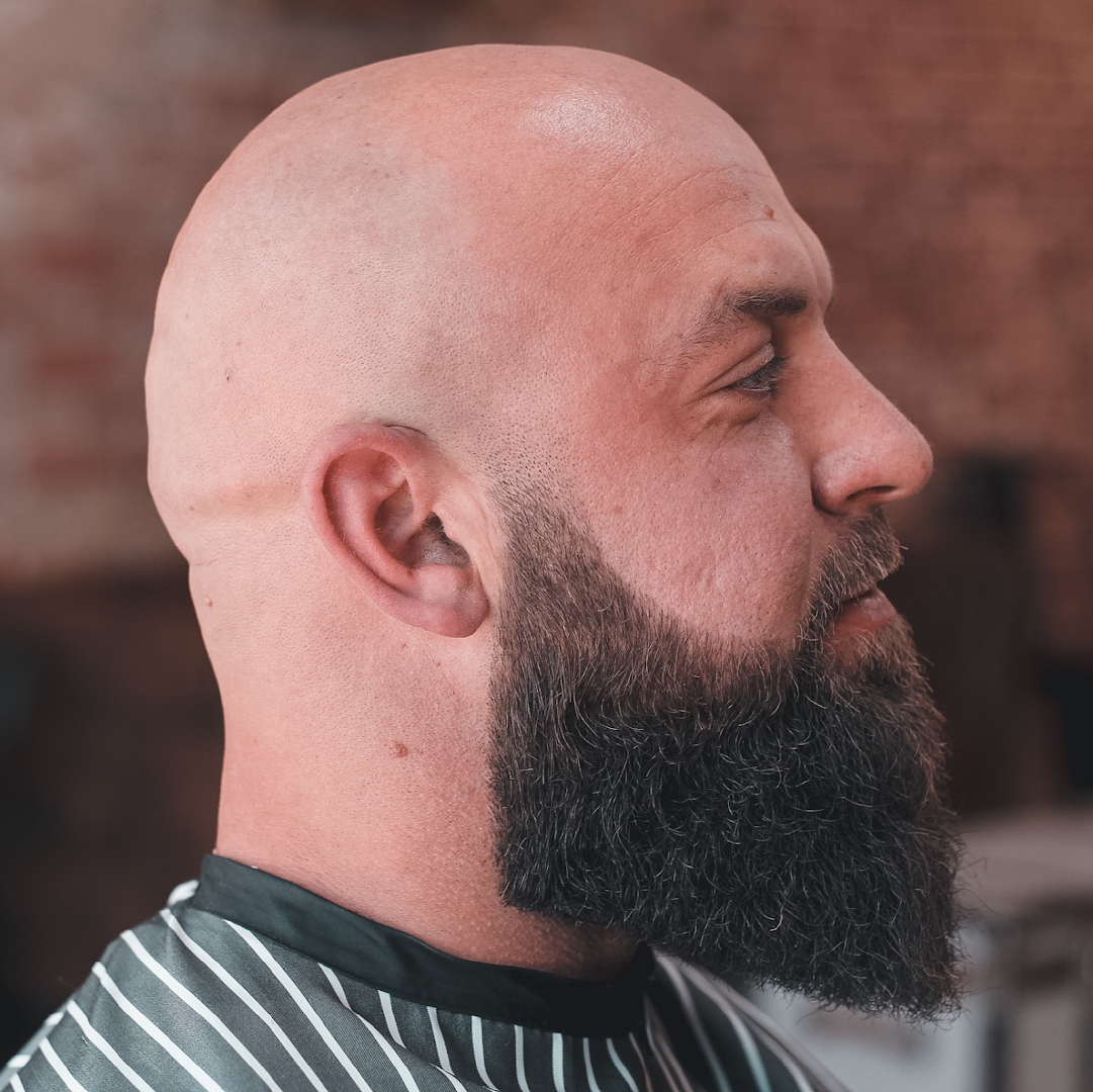 A full beard, neatly shaped and trimmed, photographed inside Amunra Barbershop