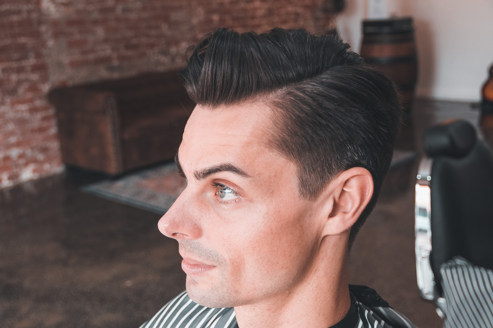 A styled quiff against the brick wall at Amunra Barbershop